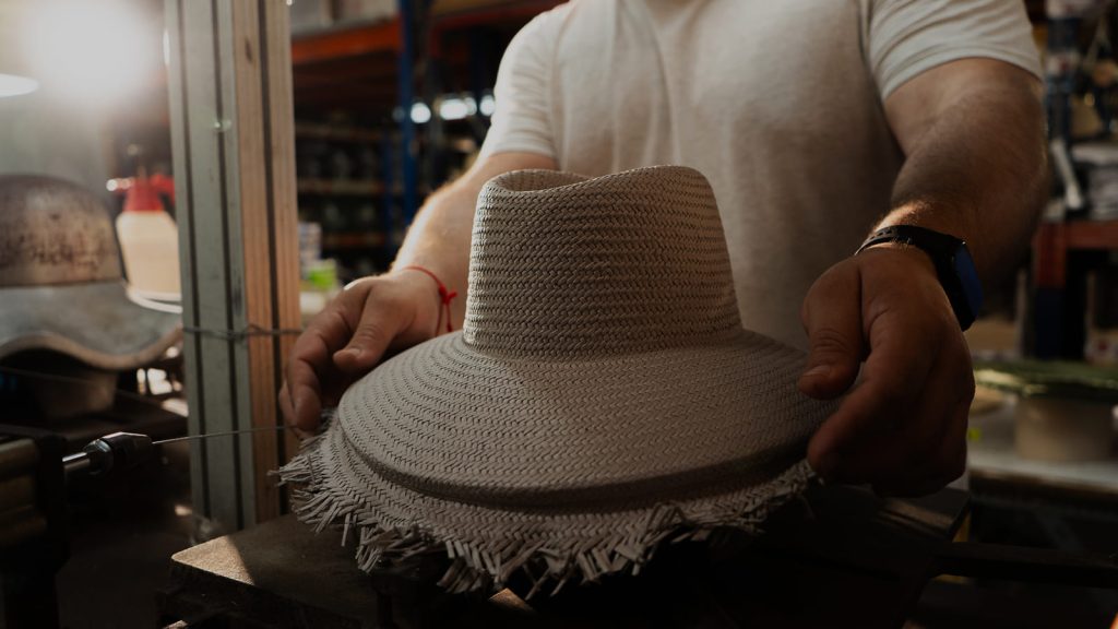 Sombrero panamá de paja junto a caja artesanal de Costa y Soler.