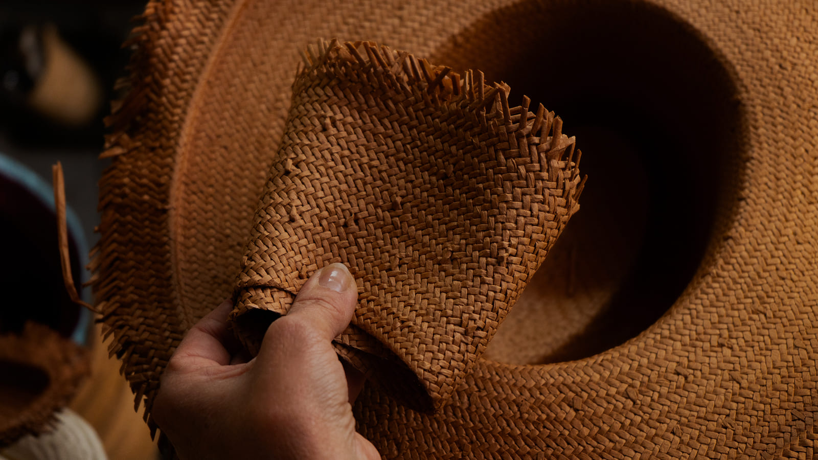 Detalle del trenzado de paja de un sombrero artesanal en fabricación.