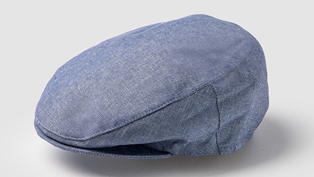 Gorra plana de lino azul con paneles laterales cosidos, vista en tres cuartos